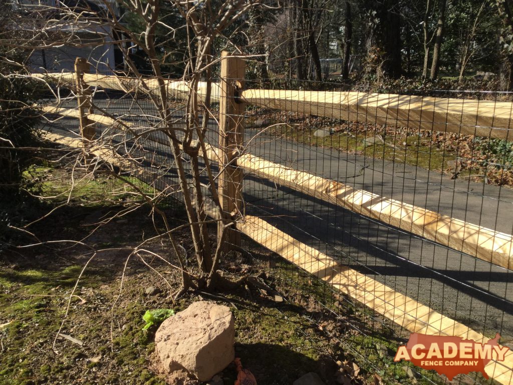 This is a rustic split, post and rail wood fence material, with welded wire mesh attached, installation in Long Valley, Morris County, NJ.